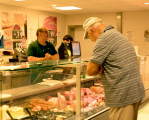 Ein Mann bei der Arbeit an der Fleischtheke im CAP Markt.